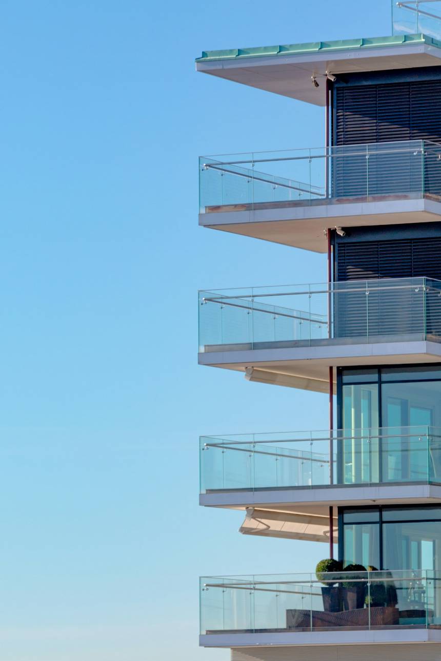 Varandas de vidro de um edifício moderno contra o céu azul.